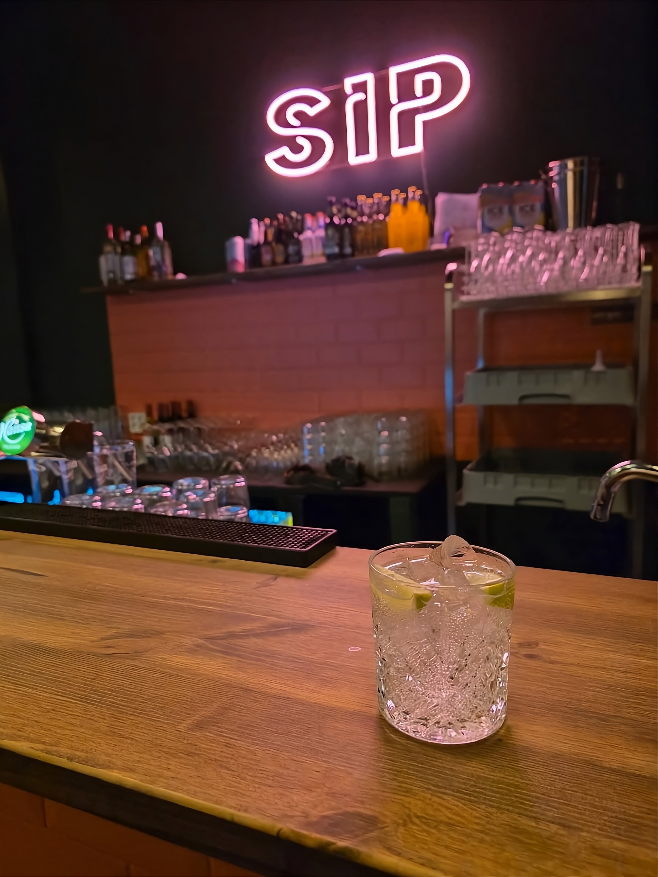 Bar-disken på SIP med neonskilt og en drink